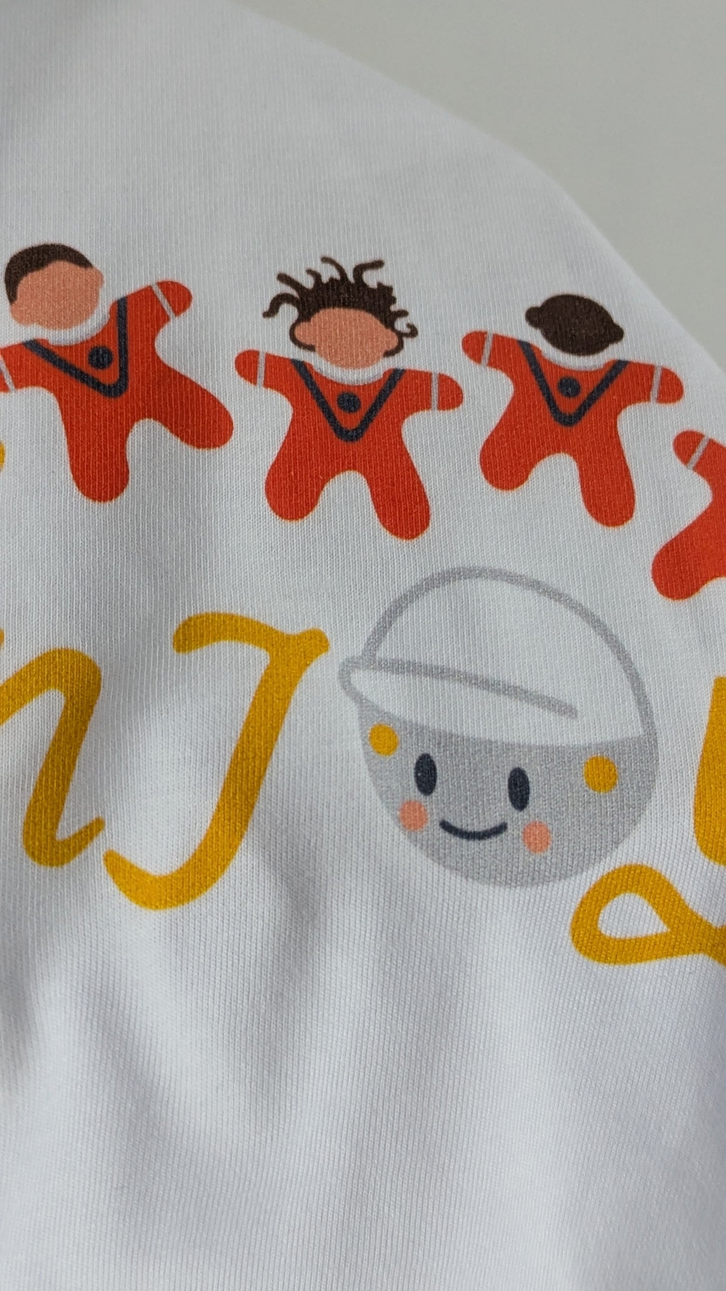 Close up of a white t-shirt with colourful graphics and text saying 'copy, moon joy' . This is an kids t-shirt sized 12-13 years.